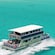 A double decker ferry carries passengers toward a narrow island